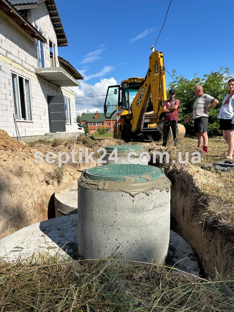 Готовий септик з бетонних кілець з люком біля приватного будинку